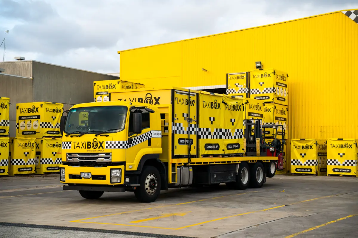 Yellow TAXIBOX truck outside of the Ormeau storage facility